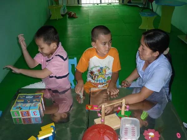 Cô giáo ở trường dạy trẻ chuyên biệt Khai Trí đang dạy 2 trẻ bị tự kỷ. Ảnh: L.N