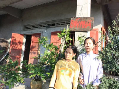 Vợ con ông Thành trước ngôi nhà nơi xảy ra vụ án