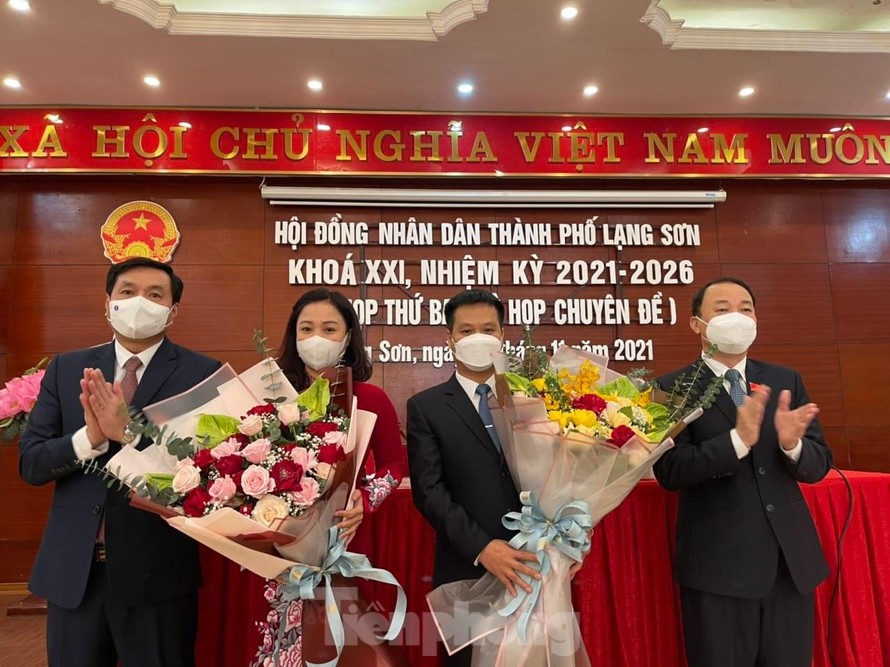 Tân Phó Chủ tịch UBND thành phố Lạng Sơn Nguyễn Thị Hồng Vân và Dương Công Dũng (giữa) nhận hoa chúc mừng của lãnh đạo thành phố -Ảnh: Duy Chiến 