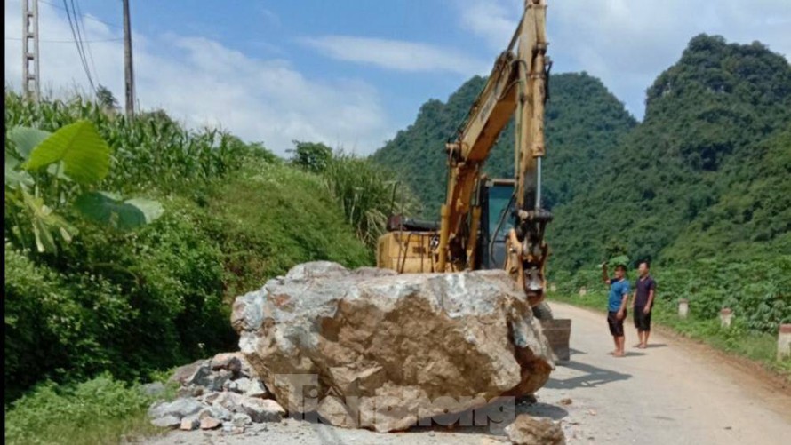 Lực lượng chức năng huy động máy móc giải tỏa tảng đá .Ảnh: V. Thương