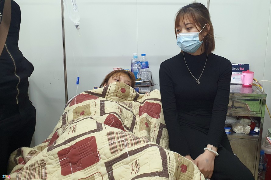 Một nạn nhân (trái) được người thân chăm sóc ở bệnh viện. Ảnh: Zing