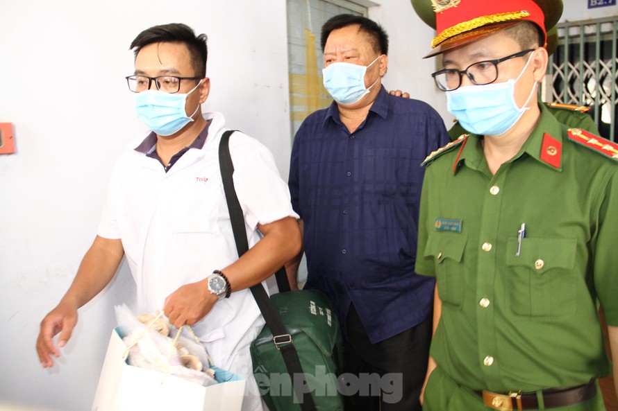 Công an Khánh Hoà dẫn giải ông Thái (áo đen, giữa) về nơi tạm giam. Ảnh LỮ HỒ