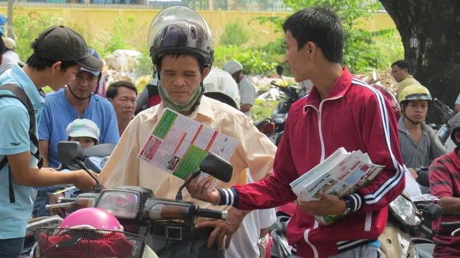 Các trường ngoài công lập phát tờ rơi cho phụ huynh và học sinh trong những ngày thi. Ảnh: Nguyễn Dũng.