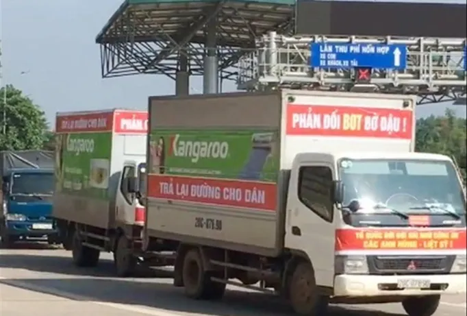Người dân treo biểu ngữ, cho xe diễu hành qua trạm thu phí Bờ Đậu để phản đối thu phí. Ảnh: A.T.