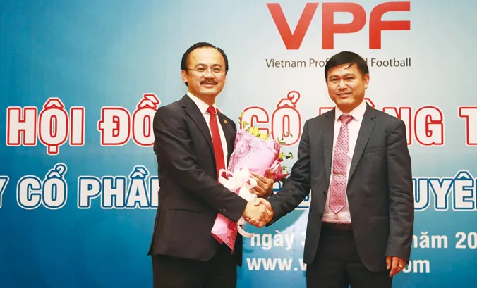 Chủ tịch VPF khóa 3 Trần Anh Tú (phải) nhận hoa chúc mừng từ Chủ tịch VPF khóa 2 Võ Quốc Thắng. Ảnh: VSI.