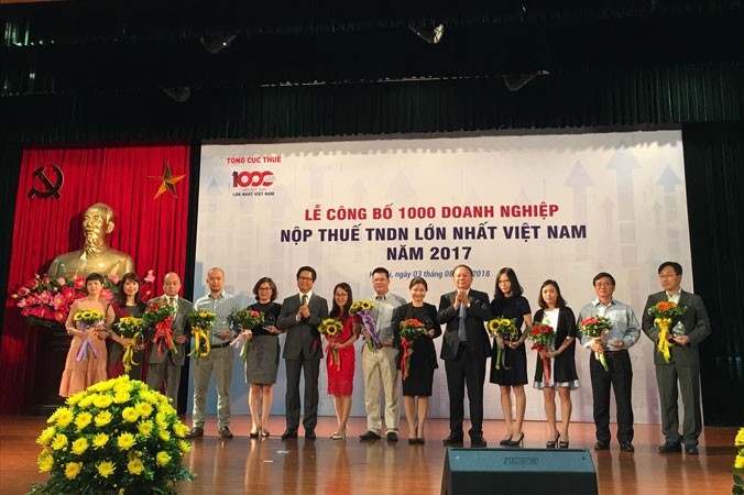 Lãnh đạo VCCI và Tổng cục Thuế trao kỷ niệm chương và hoa cho các DN trong bảng xếp hạng 1.000 DN nộp thuế TNDN nhiều nhất năm 2017. Ảnh: Tuấn Nguyễn.