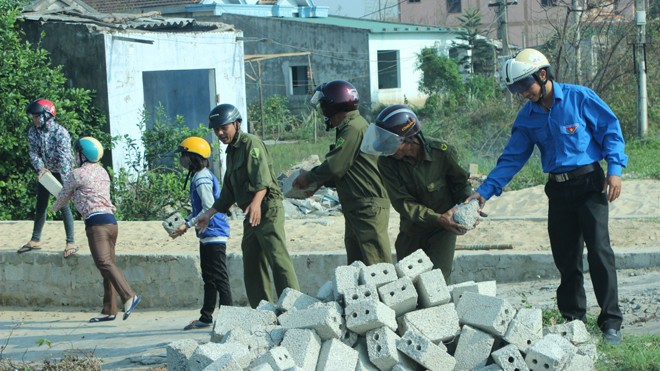 Công an xã Quảng Trạch, Quảng Bình cùng dân xếp gạch làm đường. Ảnh: Hồng Vĩnh