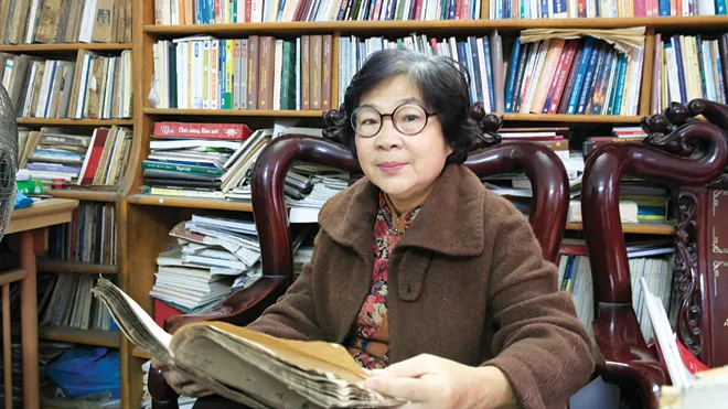 Đỗ Bạch Mai bên di cảo của chồng. Ảnh: Hồng Vĩnh