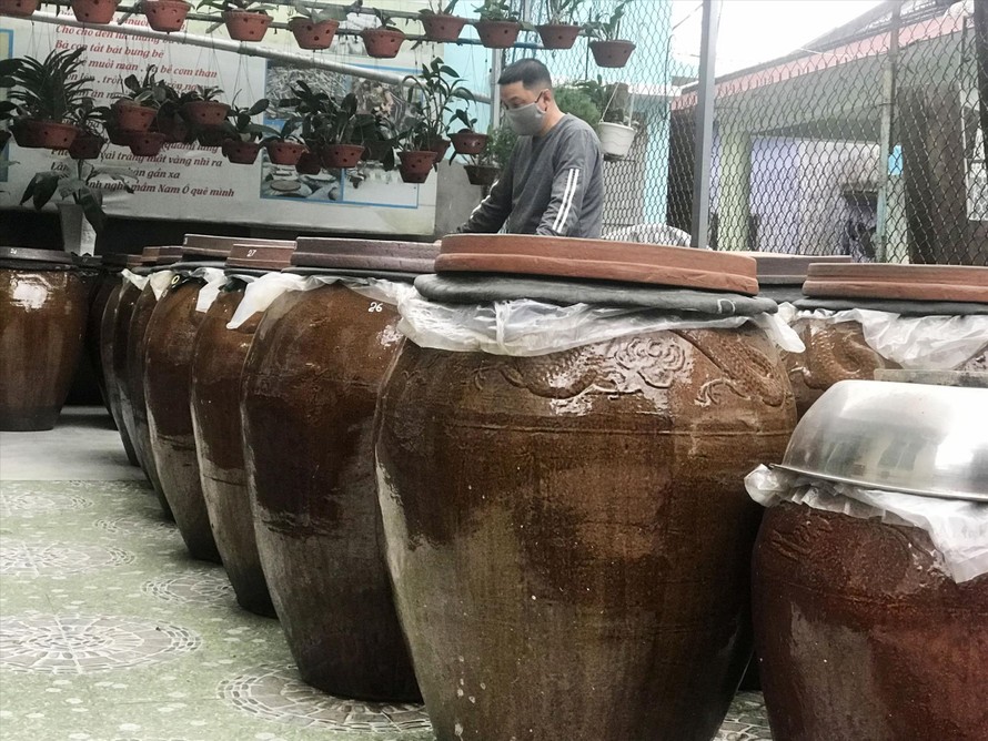 Anh Bùi Thanh Phú bên những lu mắm thành phẩm chuẩn bị xuất bán dịp Tết ảnh: Thái Lâm 
