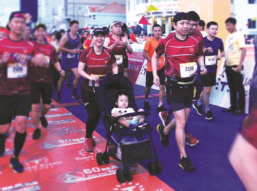 Gia đình chị Nguyễn Quỳnh Chi - Trần Phan Linh (38 tuổi) cùng con trai trên xe nôi xuất phát Ảnh: Xuân Tùng