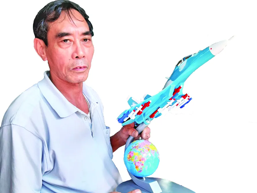 Ông Bùi Xuân Thành với chiếc máy bay chiến đấu mô hình đã hoàn thành Ảnh: Nguyễn Thành