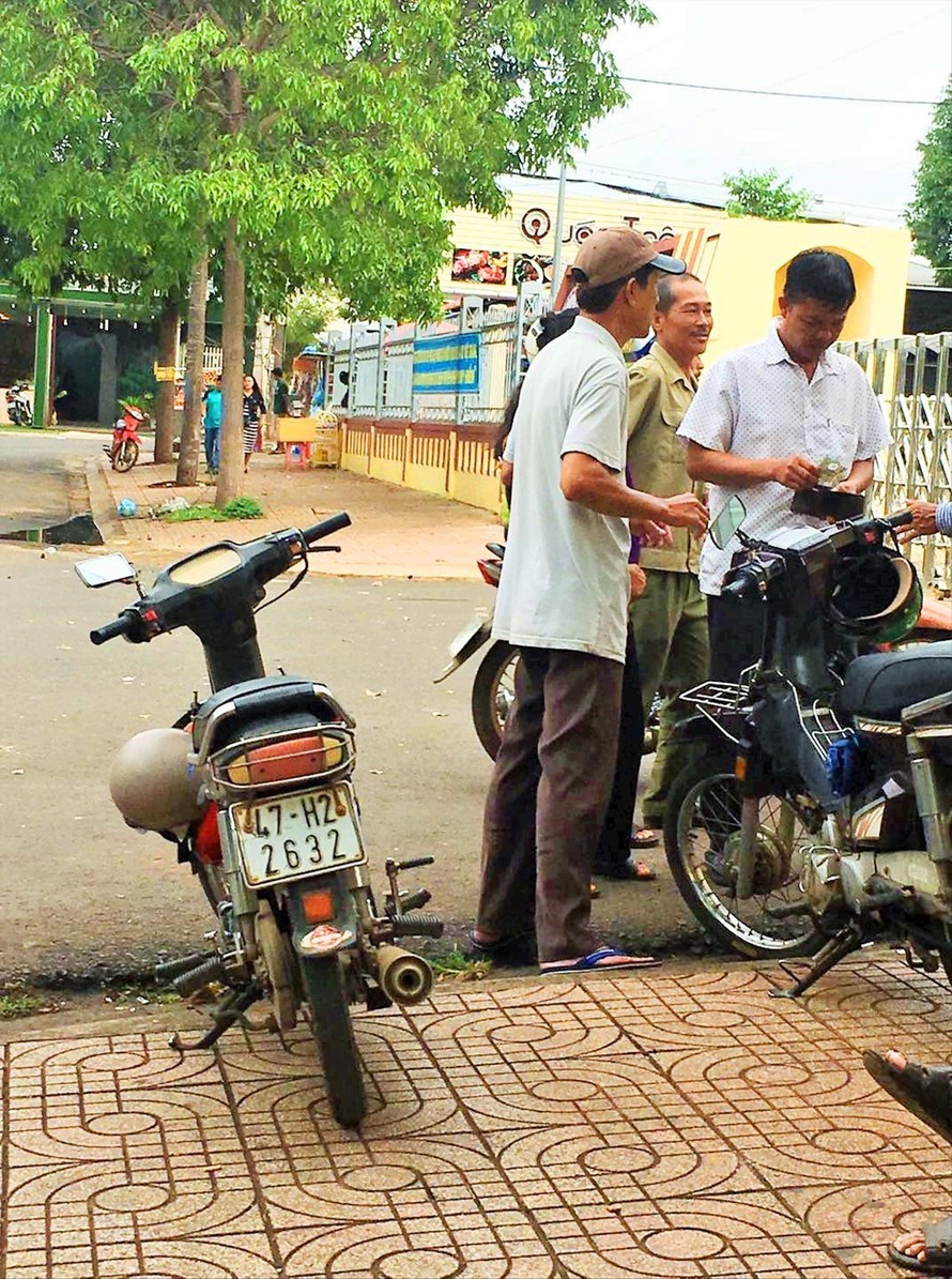 “Cò bán số” nhận tiền từ bệnh nhân ngay cạnh chốt bảo vệ ở cổng BV Ảnh: Nhất Vương