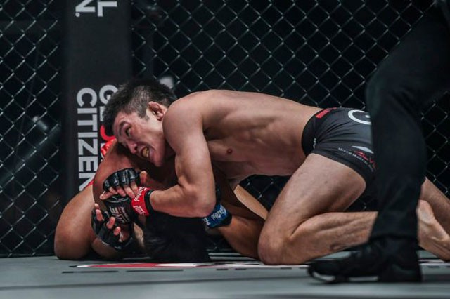 Shinya Aoki khóa cổ khiến đối thủ đành phải đầu hàng.