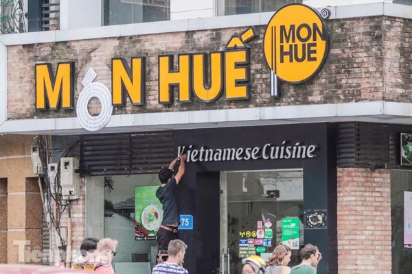 Nhân viên đang tháo dỡ biển hiệu Món Huế - ảnh Duy Phạm