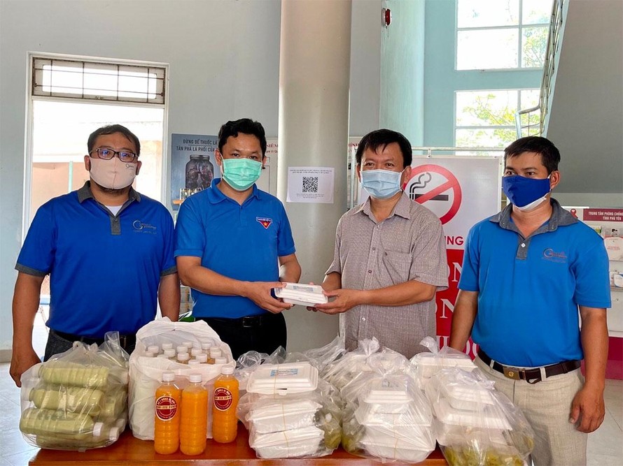 Bí thư Tỉnh Đoàn Phú Yên Phan Xuân Hạnh hỗ trợ cơm và nước uống cho y, bác sĩ Trung tâm kiểm soát bệnh tật Phú Yên - Ảnh: Huyền Oanh