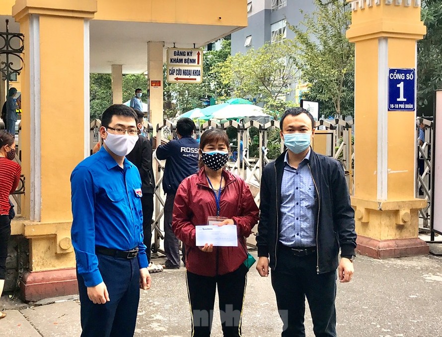 Anh Nguyễn Thái Hà, Bí thư đoàn Cơ quan Trung ương đoàn và anh Phạm Tuấn Anh, Bí thư Đoàn cơ sở báo Tiền phong trao tiền hỗ trợ cho mẹ tình nguyện viên Hoàng Văn Tuấn.