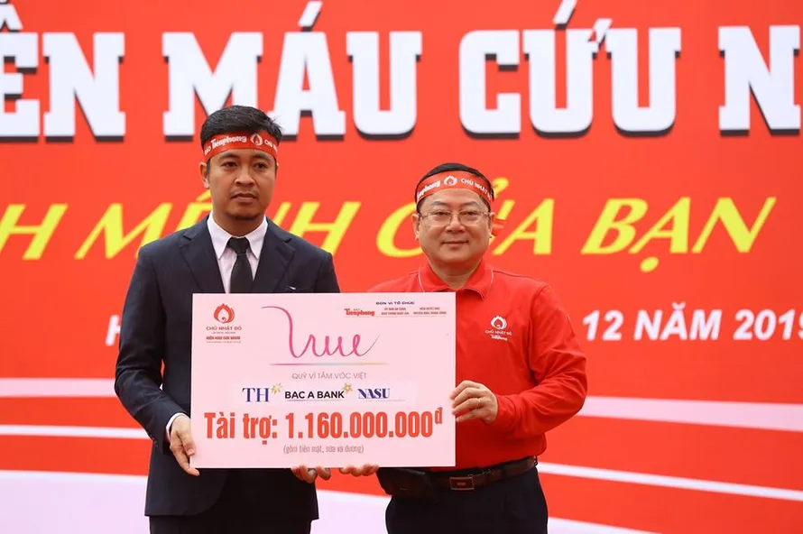 Đại diện Quỹ Vì Tầm Vóc Việt trao biển tài trợ cho Tổng Biên tập Báo Tiền Phong Lê Xuân Sơn - Trưởng Ban Tổ chức Chủ nhật đỏ