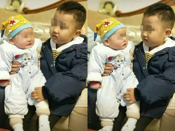 Vẻ mặt ngán ngẩm của cậu bé khi phải bế em khiến cư dân mạng thích thú